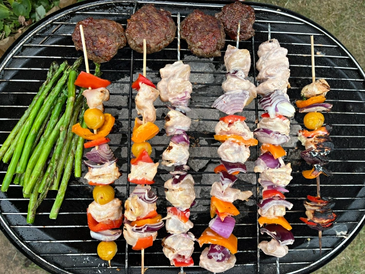gluten-free shish kebabs on bbq with mini burgers and asparagus
